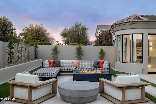 patio terrace at dusk featuring an outdoor living space with a fire pit