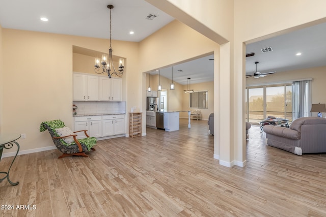 interior space featuring light hardwood / wood-style floors, white cabinetry, hanging light fixtures, and ceiling fan with notable chandelier