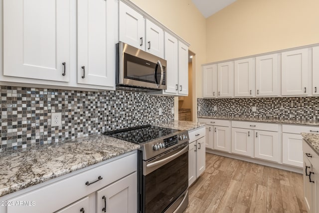 kitchen with decorative backsplash, light hardwood / wood-style flooring, stainless steel appliances, and white cabinets