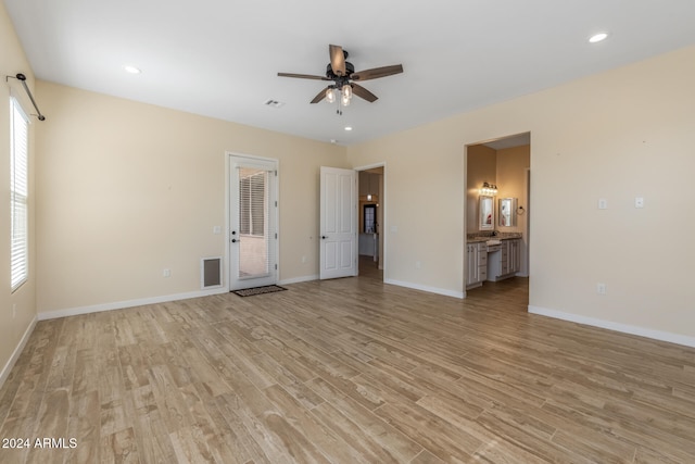 unfurnished living room with light wood-type flooring and ceiling fan