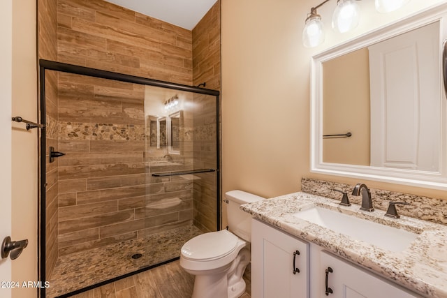 bathroom featuring vanity, hardwood / wood-style flooring, toilet, and walk in shower