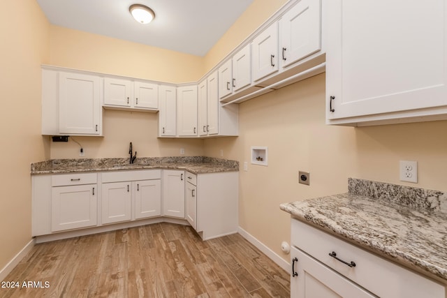 kitchen featuring light hardwood / wood-style flooring, light stone counters, and white cabinets