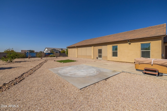 rear view of house with a patio and a hot tub