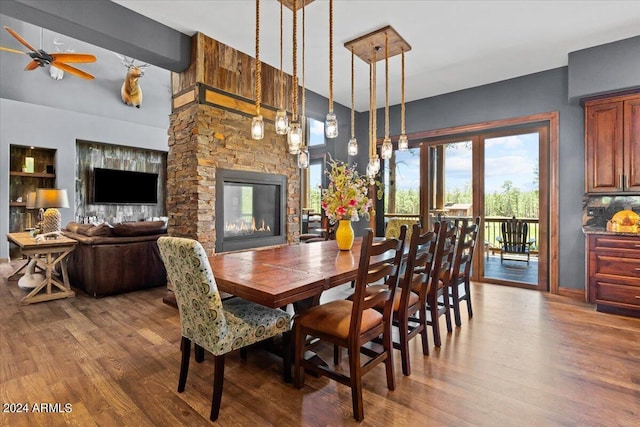 dining room with ceiling fan, hardwood / wood-style floors, and a fireplace