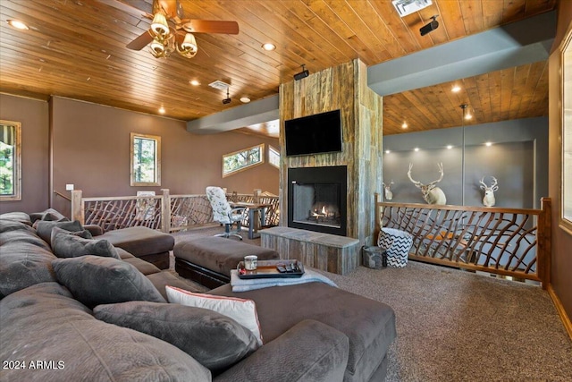 carpeted living room featuring ceiling fan, wooden ceiling, and a fireplace