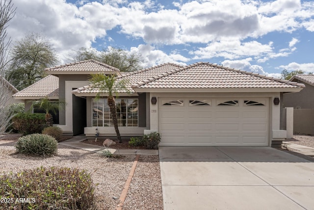 view of front facade featuring a tile roof, a garage, driveway, and stucco siding