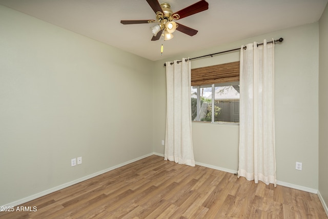 spare room featuring baseboards, light wood finished floors, and ceiling fan