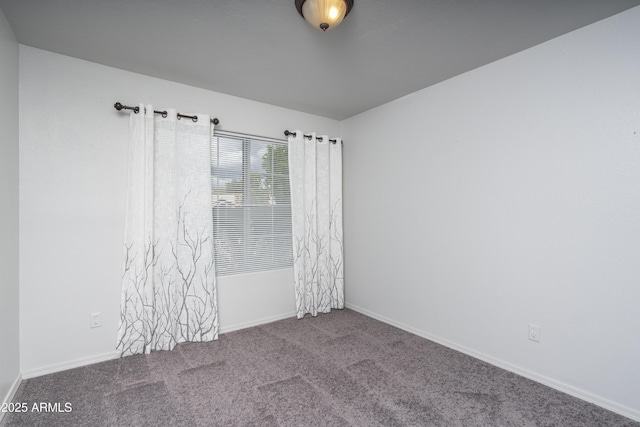 carpeted spare room featuring baseboards