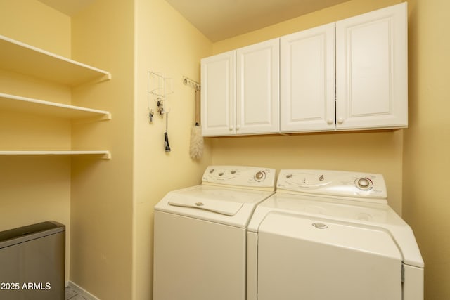 clothes washing area featuring cabinet space and washing machine and dryer