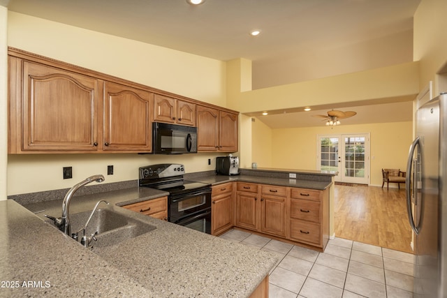 kitchen with a ceiling fan, a peninsula, light tile patterned flooring, a sink, and black appliances