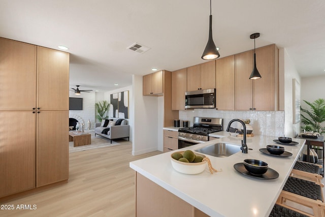 1720 W Behrend Dr, Phoenix, AZ 85027 - kitchen featuring appliances with stainless steel finishes, a sink, ceiling fan, light countertops, and a peninsula
