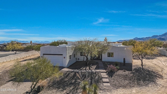 pueblo-style home featuring a mountain view and a garage