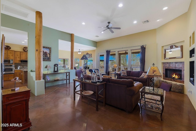 living room with ceiling fan, a fireplace, and a healthy amount of sunlight