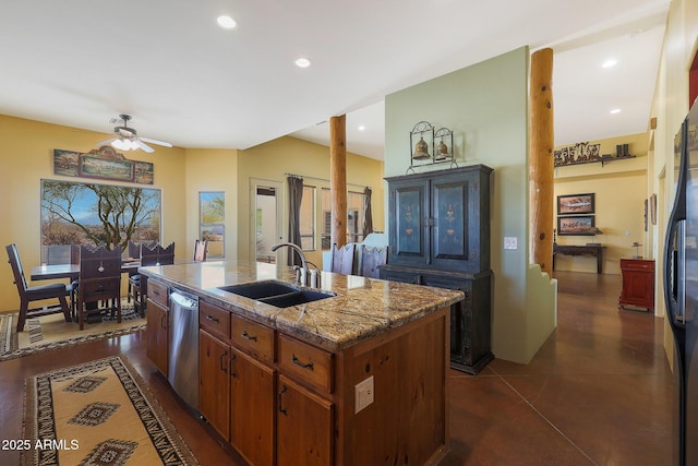 kitchen featuring a center island with sink, dark tile patterned flooring, sink, ceiling fan, and appliances with stainless steel finishes