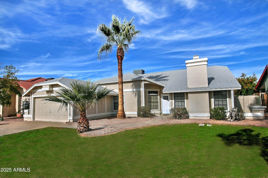 view of front of property with a front yard and a garage