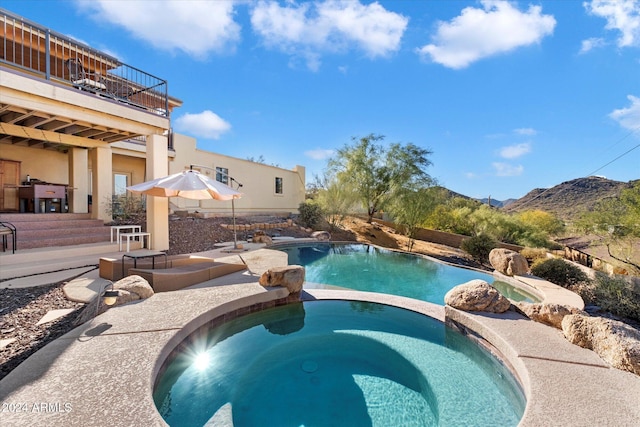 view of swimming pool featuring a mountain view and an in ground hot tub