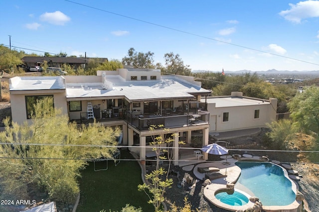 rear view of house featuring a balcony, a patio area, and a fenced in pool