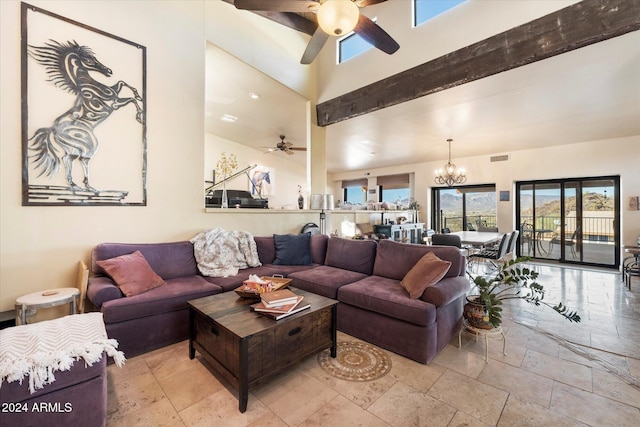 living room featuring a towering ceiling, beamed ceiling, and ceiling fan with notable chandelier