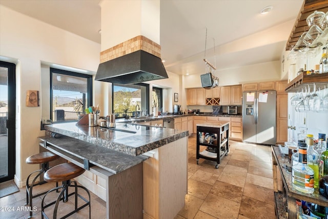 kitchen featuring light brown cabinets, sink, a breakfast bar area, kitchen peninsula, and stainless steel appliances