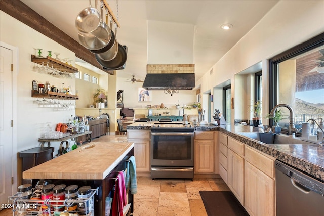 kitchen with light brown cabinets, butcher block counters, sink, appliances with stainless steel finishes, and kitchen peninsula