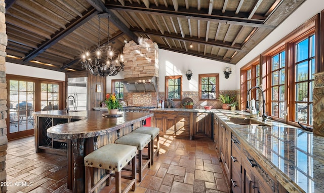 kitchen featuring tasteful backsplash, beam ceiling, sink, and high vaulted ceiling