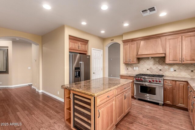 22063 N 77th St, Scottsdale, AZ 85255 - kitchen with high quality appliances, arched walkways, custom range hood, beverage cooler, and wood finished floors
