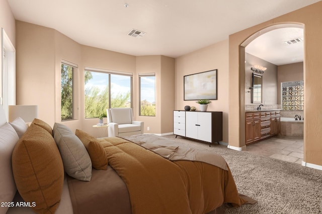 22063 N 77th St, Scottsdale, AZ 85255 - bedroom featuring arched walkways, ensuite bathroom, baseboards, and light colored carpet
