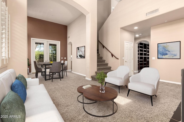 22063 N 77th St, Scottsdale, AZ 85255 - living room featuring arched walkways, stairway, carpet flooring, a high ceiling, and recessed lighting