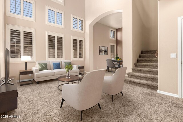 22063 N 77th St, Scottsdale, AZ 85255 - living area featuring a towering ceiling, arched walkways, stairway, baseboards, and carpet