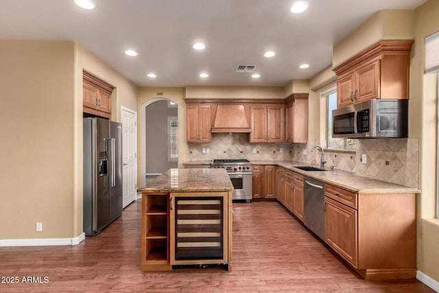 22063 N 77th St, Scottsdale, AZ 85255 - kitchen featuring premium appliances, a sink, wine cooler, arched walkways, and custom range hood