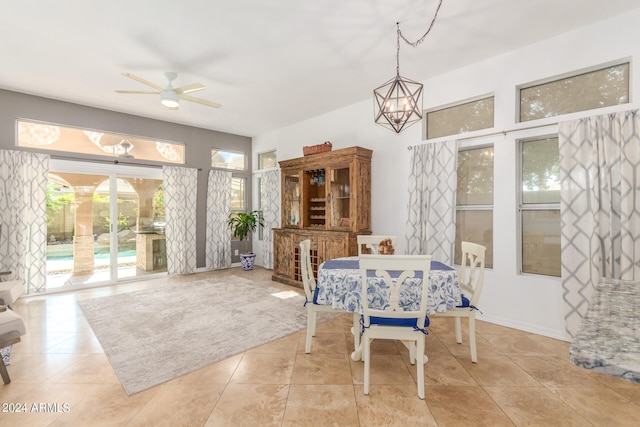 dining area with light tile patterned floors and ceiling fan with notable chandelier