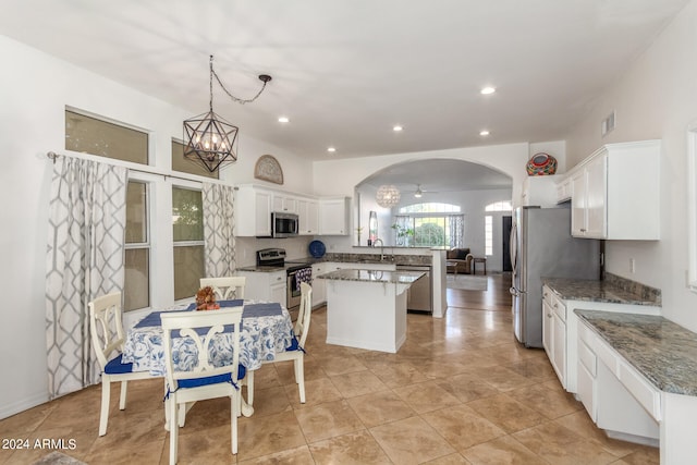 kitchen with appliances with stainless steel finishes, sink, a center island, decorative light fixtures, and white cabinets