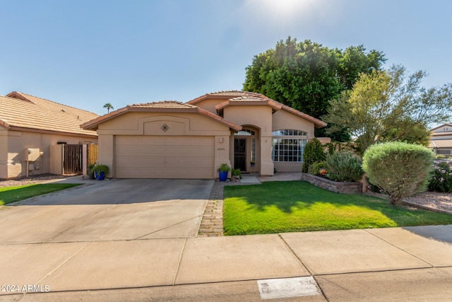 mediterranean / spanish-style house featuring a garage and a front lawn