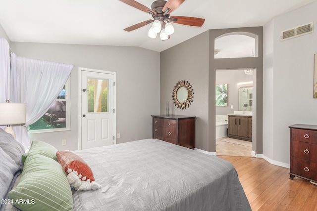 bedroom with light hardwood / wood-style floors, lofted ceiling, ensuite bathroom, and ceiling fan