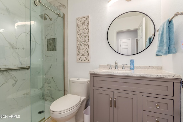 bathroom with vanity, toilet, and a shower with door