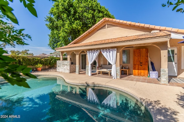 rear view of property featuring a patio and outdoor lounge area