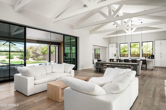 living room featuring light wood-type flooring, high vaulted ceiling, a wealth of natural light, and beam ceiling