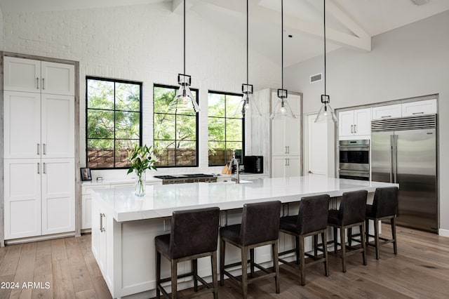 kitchen featuring a large island, stainless steel appliances, and beam ceiling