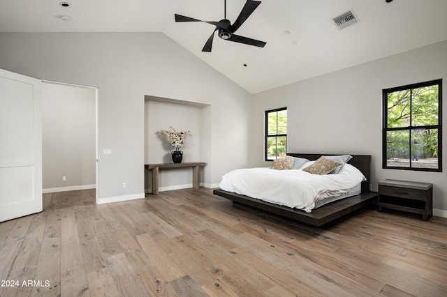 bedroom featuring high vaulted ceiling, multiple windows, ceiling fan, and light hardwood / wood-style flooring