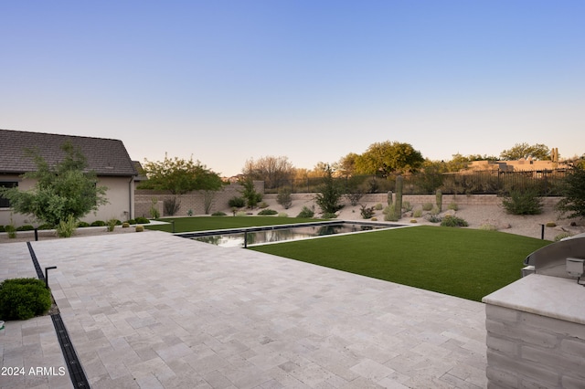 yard at dusk with a fenced in pool and a patio area