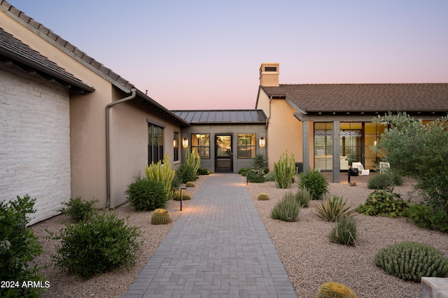 exterior entry at dusk with a patio