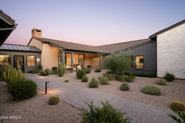 back house at dusk with a patio