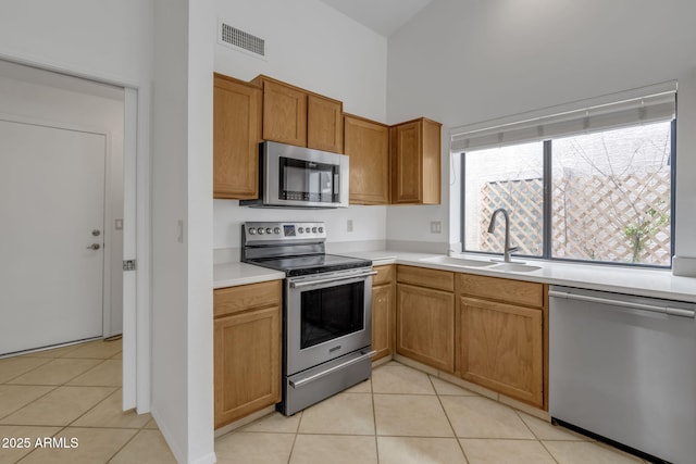 kitchen with light tile patterned floors, visible vents, appliances with stainless steel finishes, and a sink