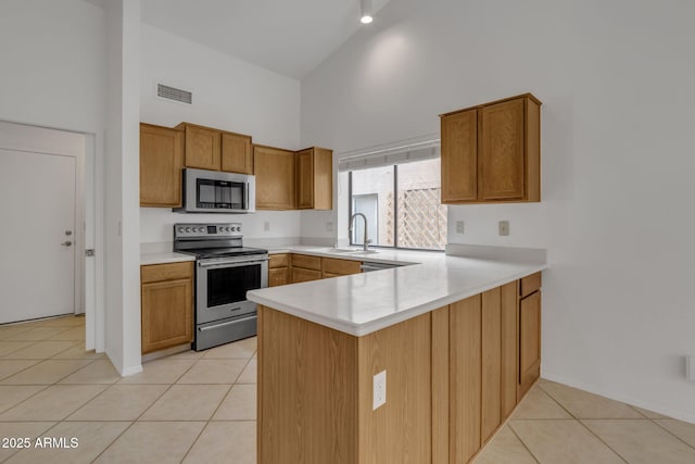 kitchen featuring visible vents, a sink, stainless steel appliances, light tile patterned flooring, and light countertops