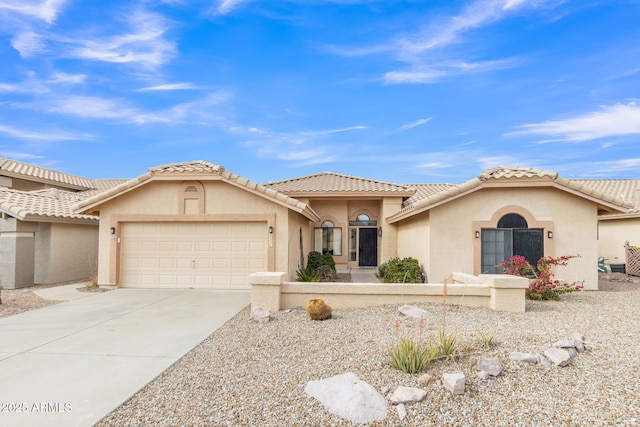 view of front of property with concrete driveway, an attached garage, a tile roof, and stucco siding