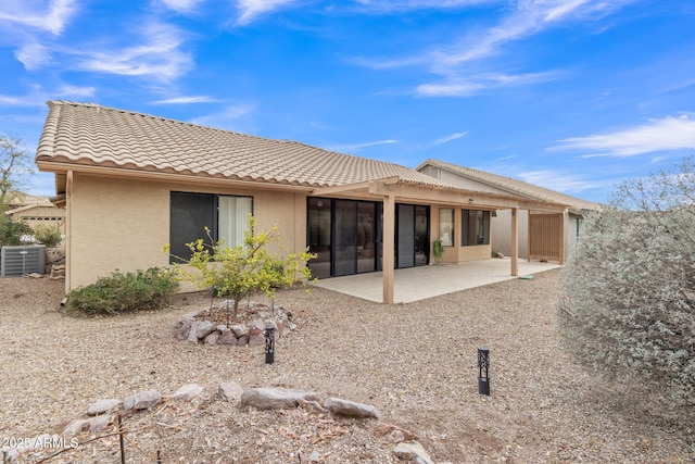 rear view of property with a patio area, cooling unit, stucco siding, and a tiled roof