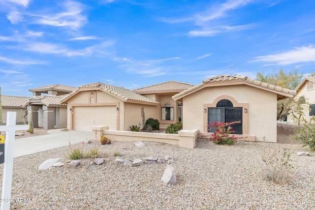 mediterranean / spanish home with concrete driveway, an attached garage, a tile roof, and stucco siding