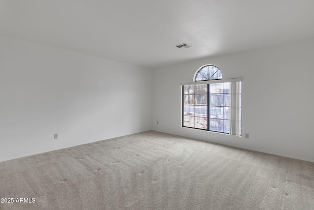 carpeted spare room featuring visible vents