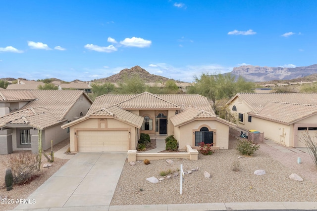 view of front of home featuring stucco siding, driveway, a tile roof, and a garage