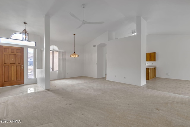 entryway featuring light tile patterned floors, light carpet, high vaulted ceiling, and a ceiling fan